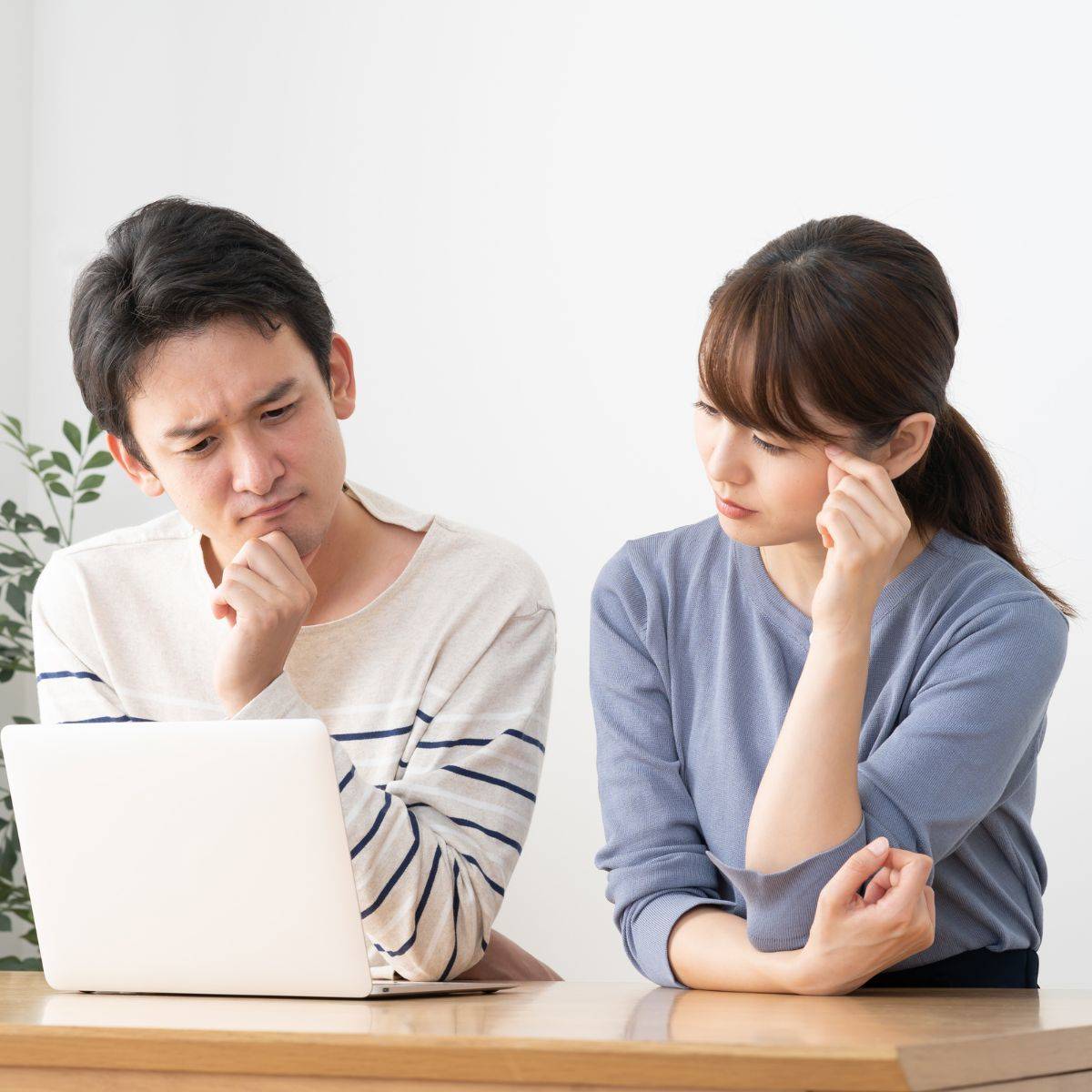パソコンを見て悩んでいる夫婦
