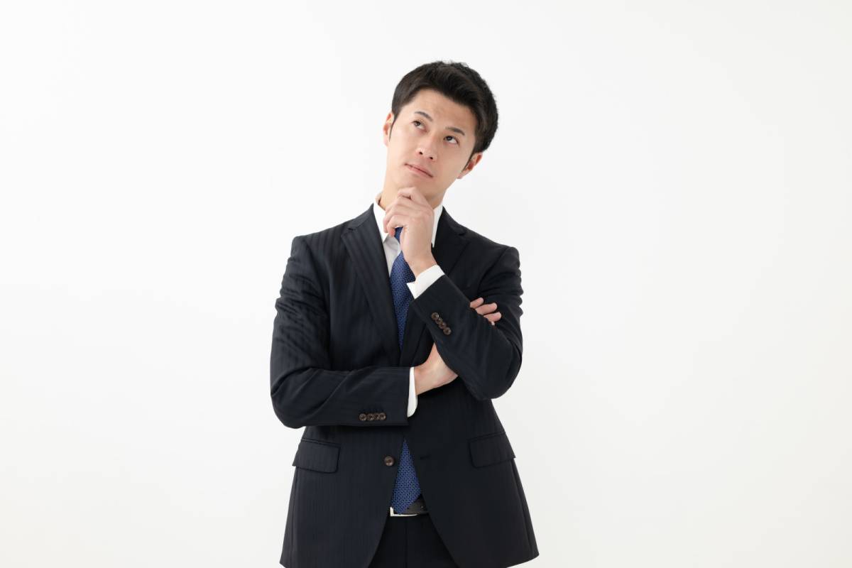 あごに手をあてて考えている男性