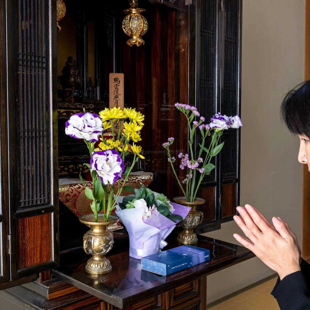 仏壇に花を供える女性
