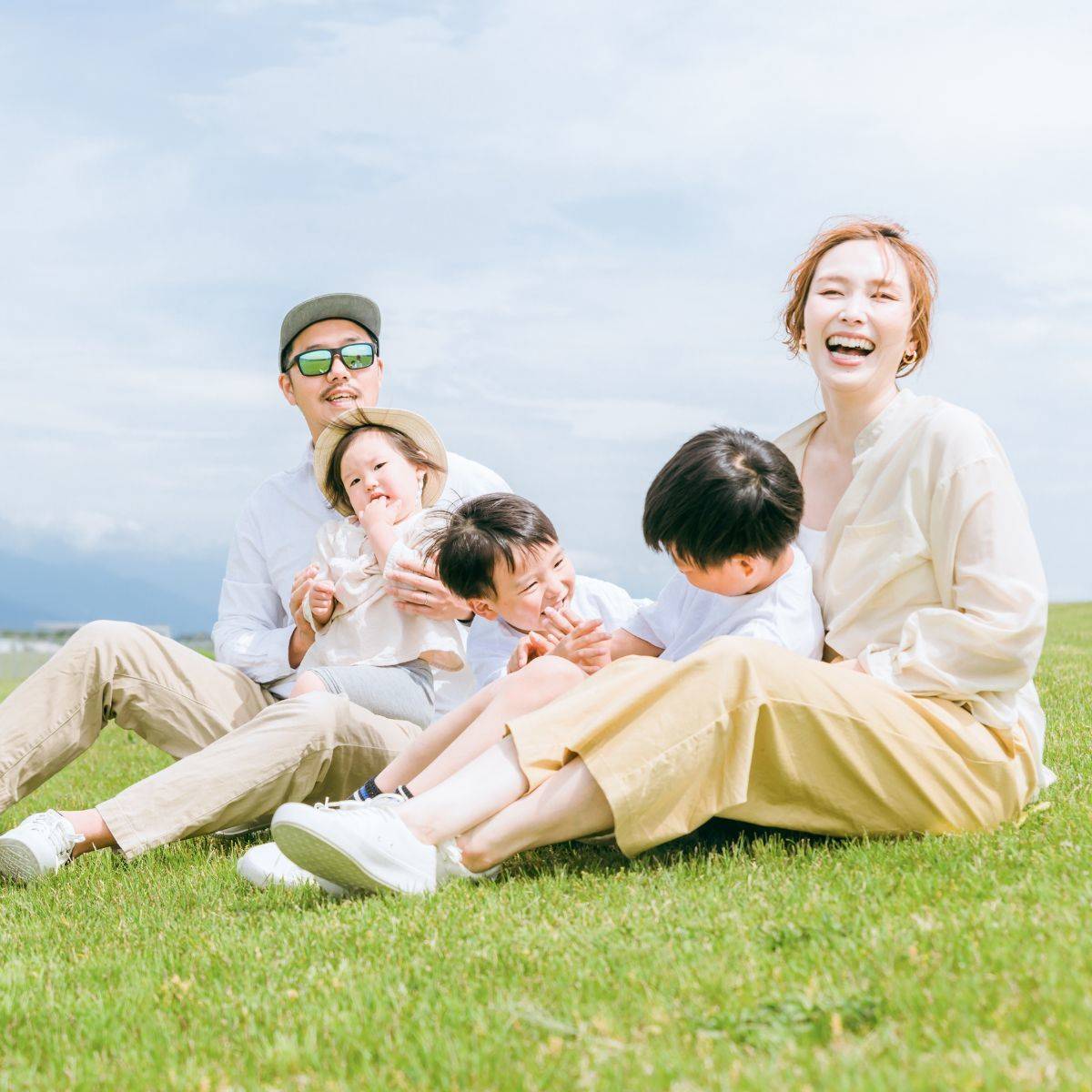 芝生に座っている5人家族