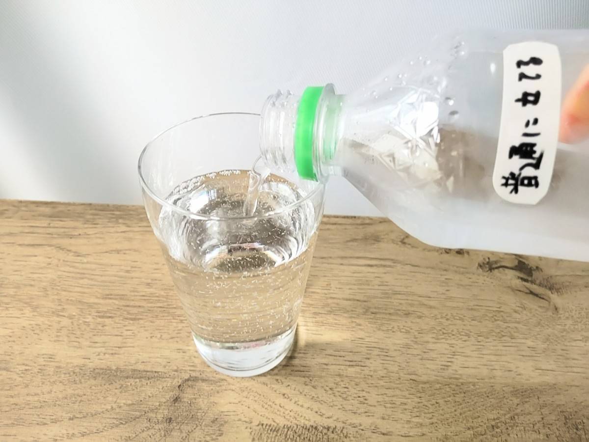 普通に立てた炭酸ペットボトルをグラスに注いでいるところ