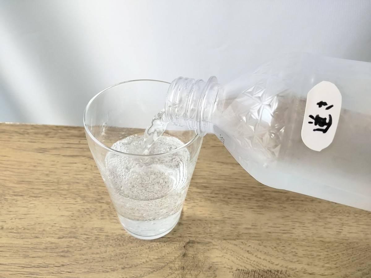 逆さまに保管した炭酸ペットボトルをグラスに注いでいるところ