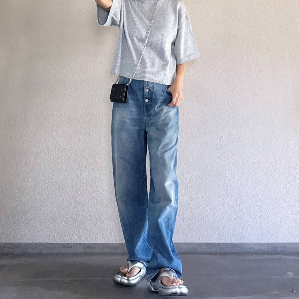 グレーTシャツにデニムパンツを合わせた女性