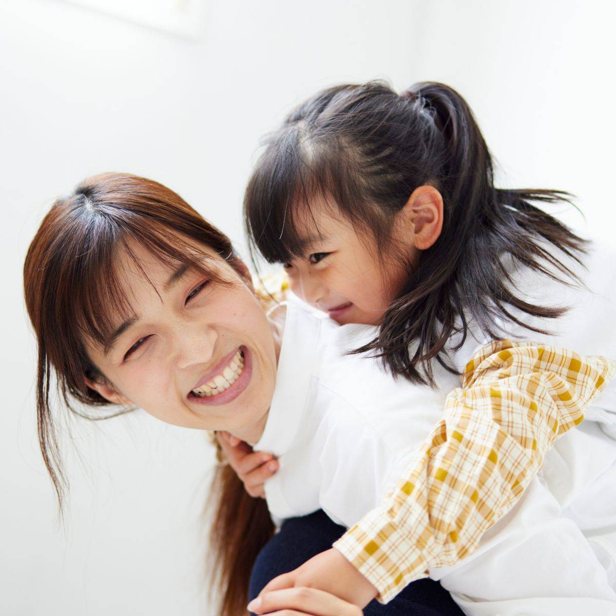 おんぶをして遊ぶ幸せそうな母親と子供