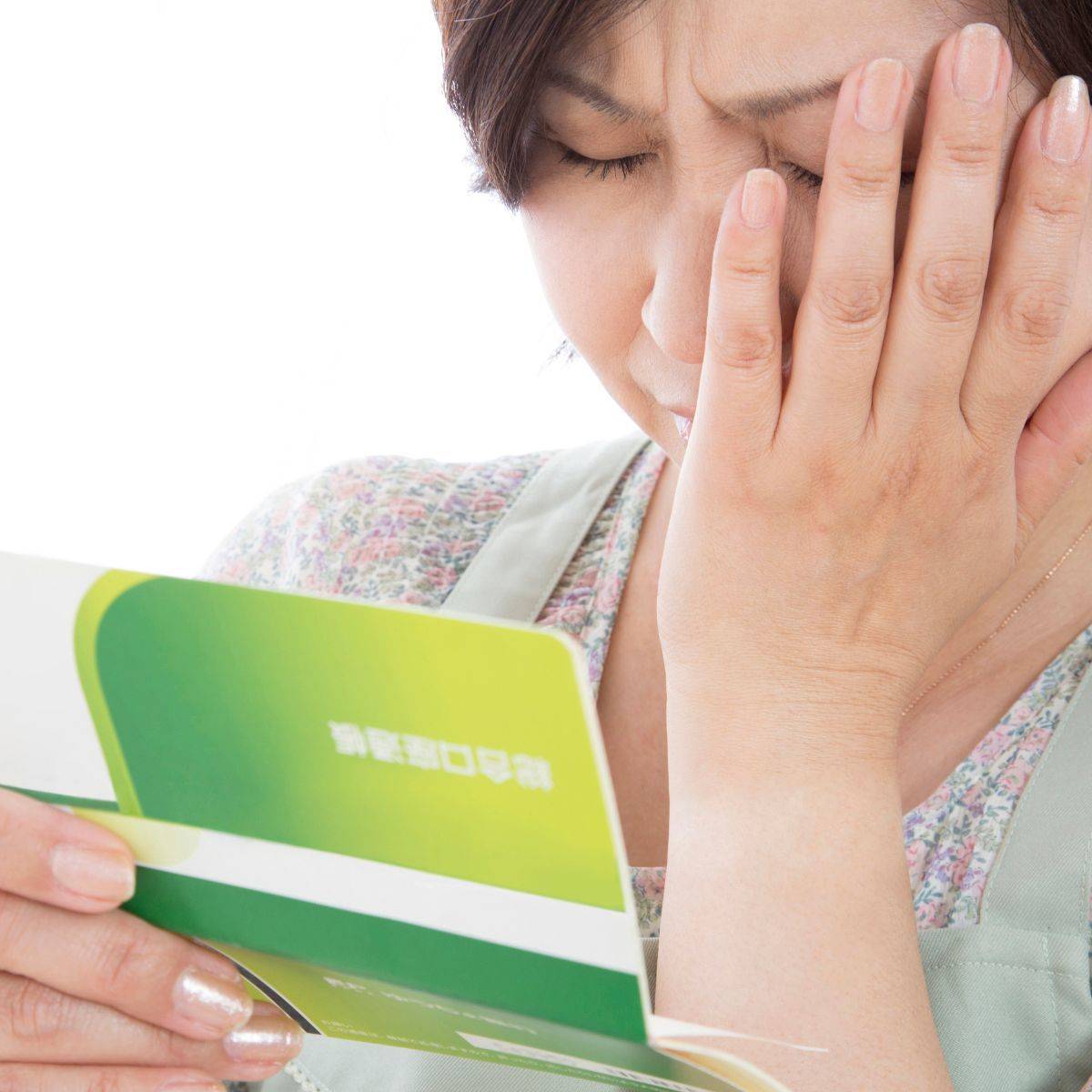 預金通帳を見る主婦