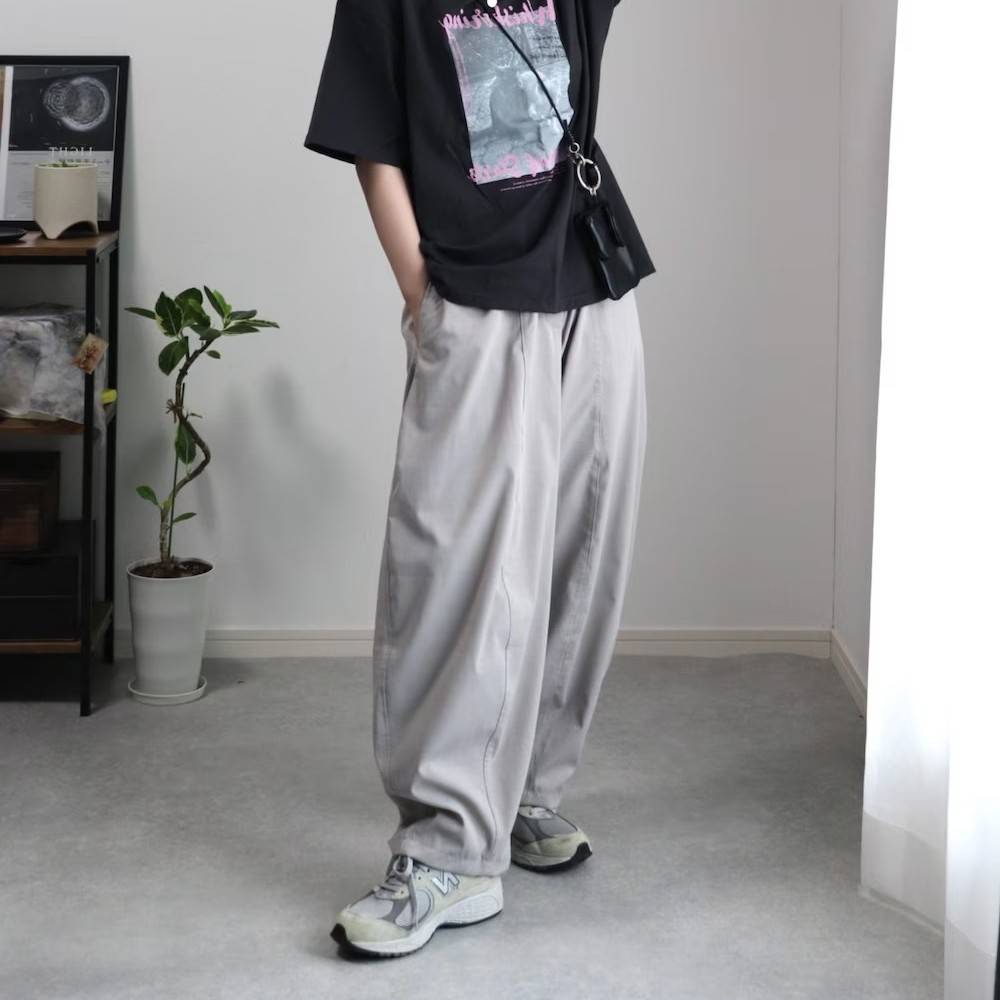 黒Tシャツにグレーパンツを合わせた女性