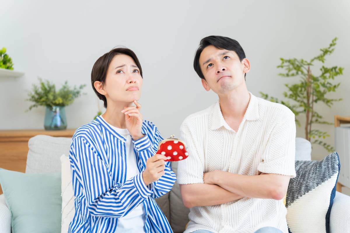 財布を手に悩んでいる夫婦
