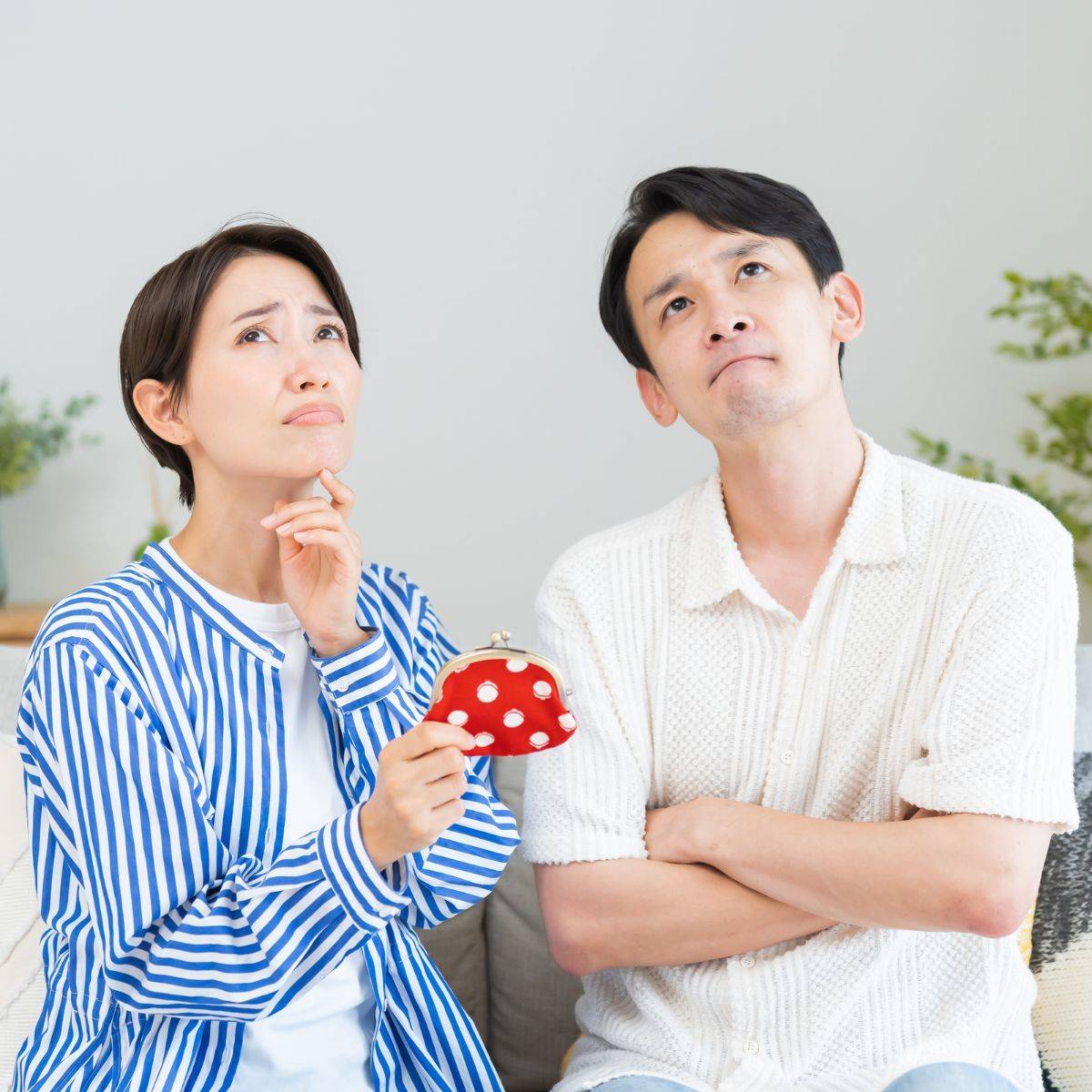 財布を手に悩んでいる夫婦