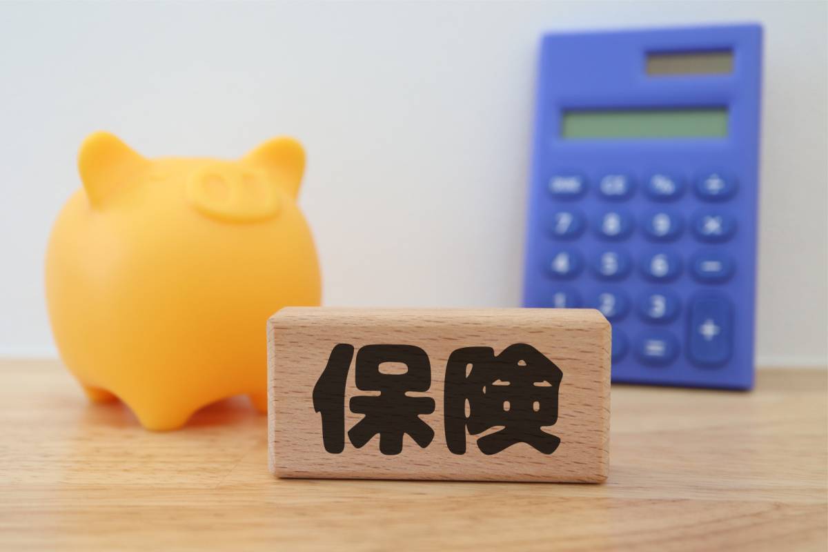 保険の文字と貯金箱と電卓