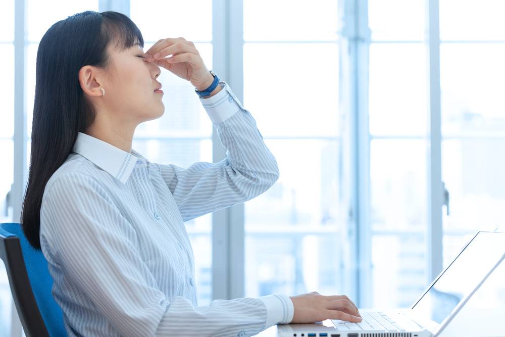 目頭をおさえる女性
