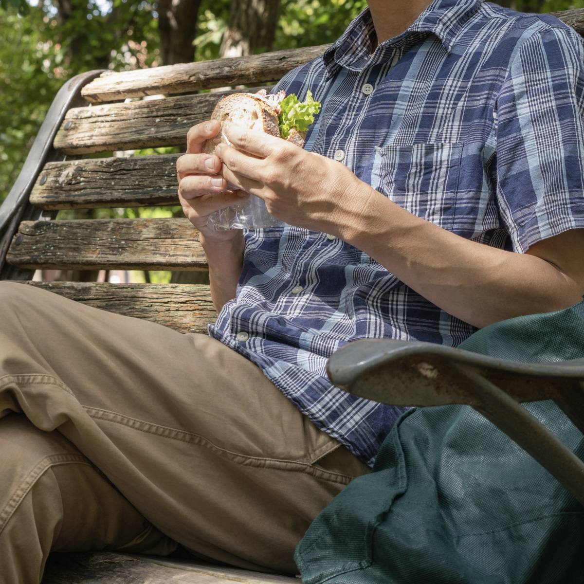 公園でサンドイッチを食べる男性