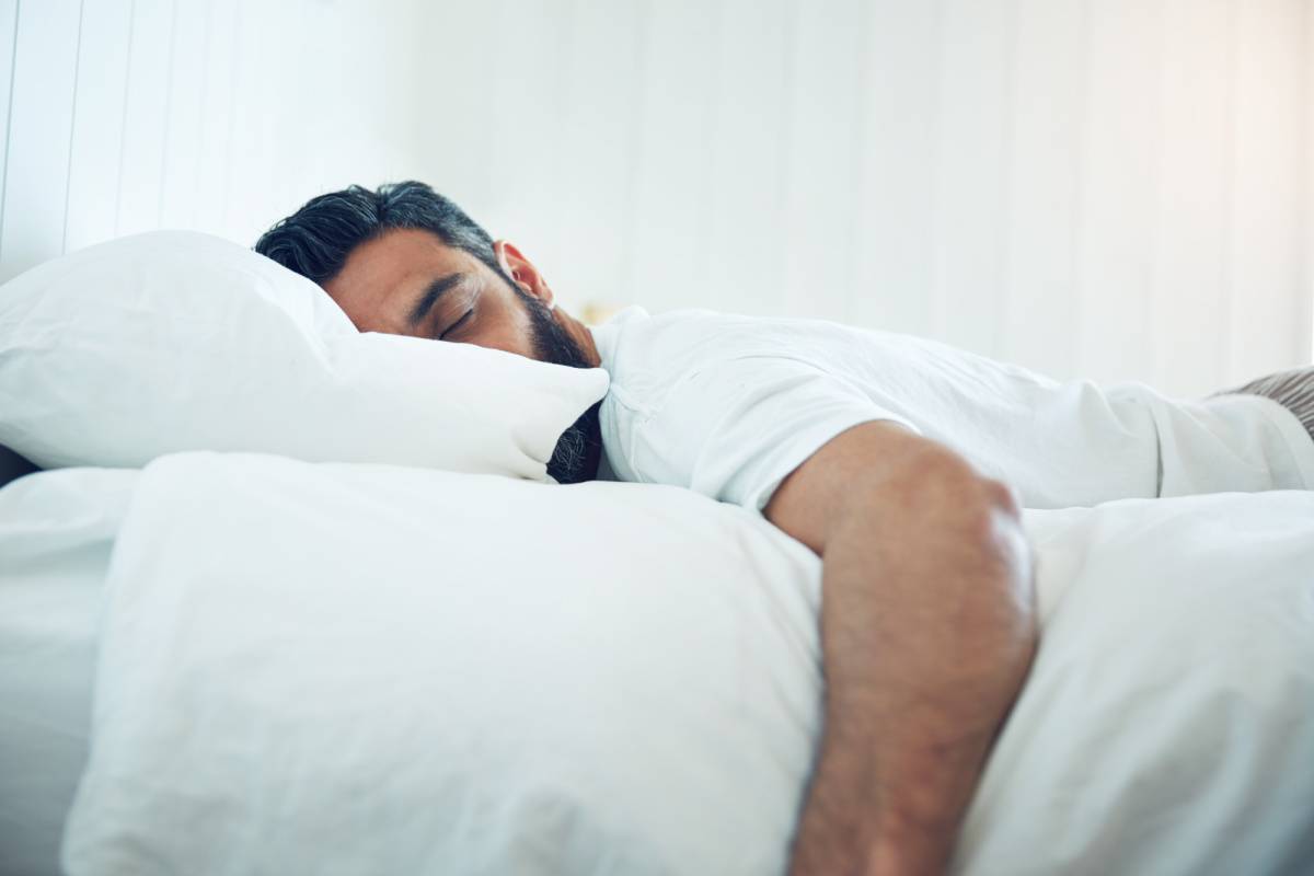 ベッドで寝る男性