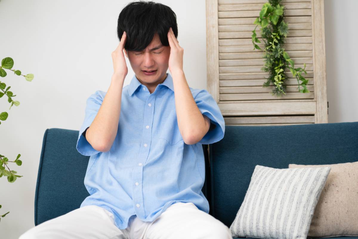 頭を押さえている男性