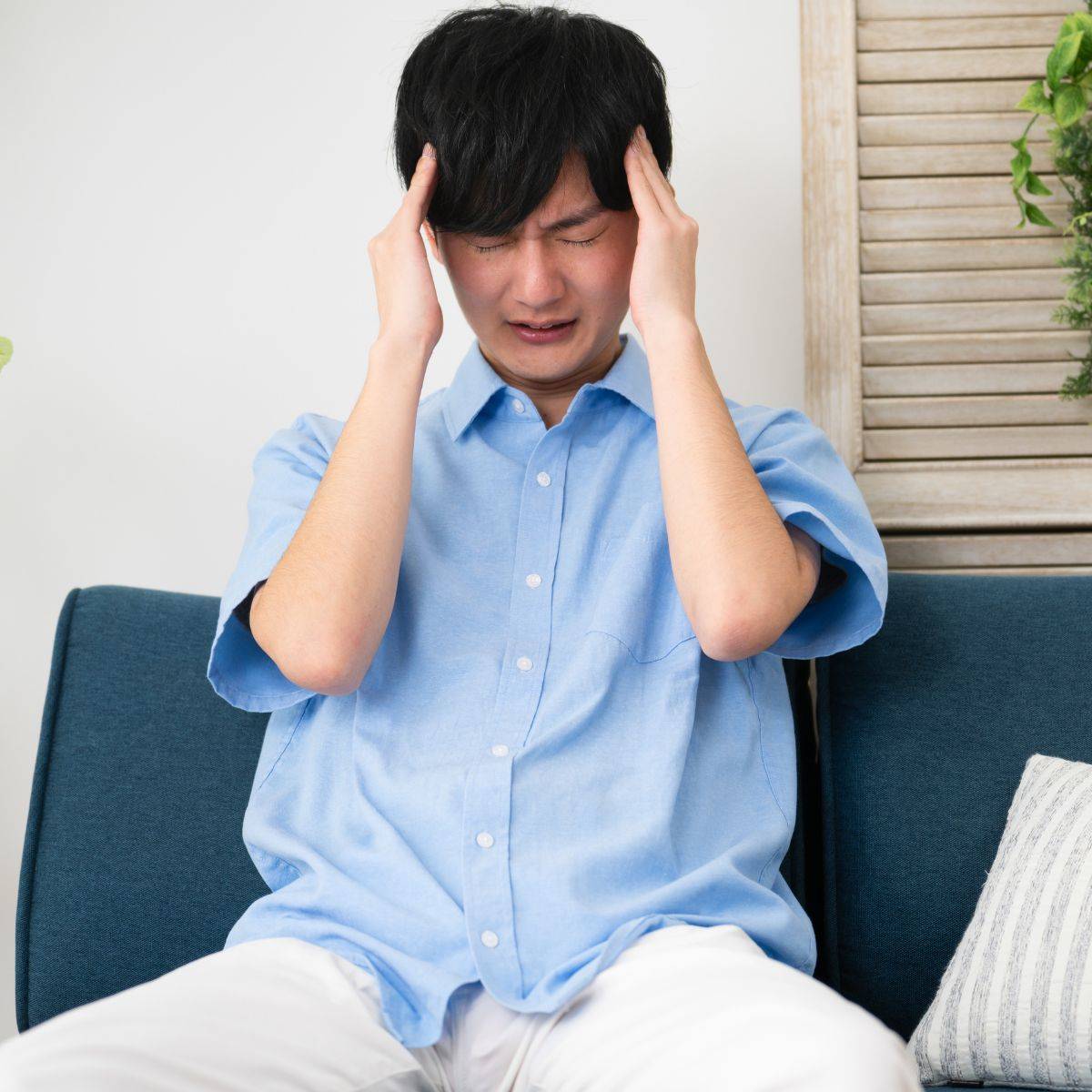 頭を押さえている男性