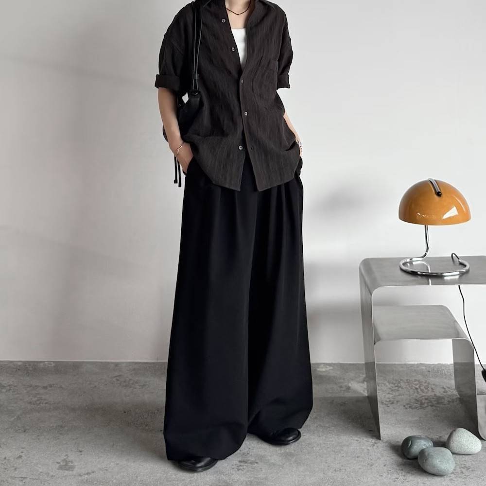 グレーのシャツに黒パンツを合わせた女性
