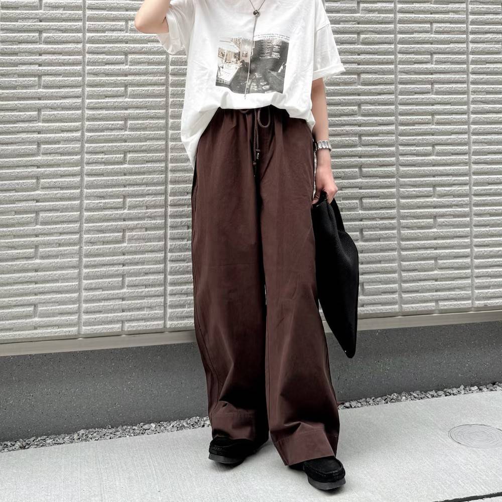 白Tシャツにブラウンのパンツを合わせた女性