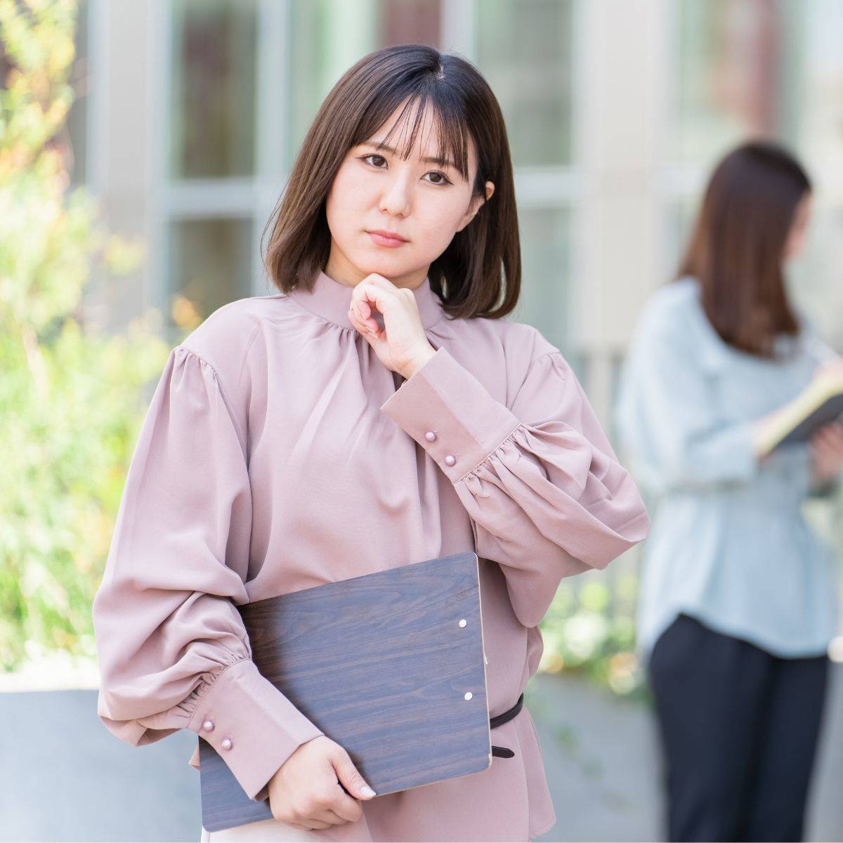オフィスの前で悩んでいる女性