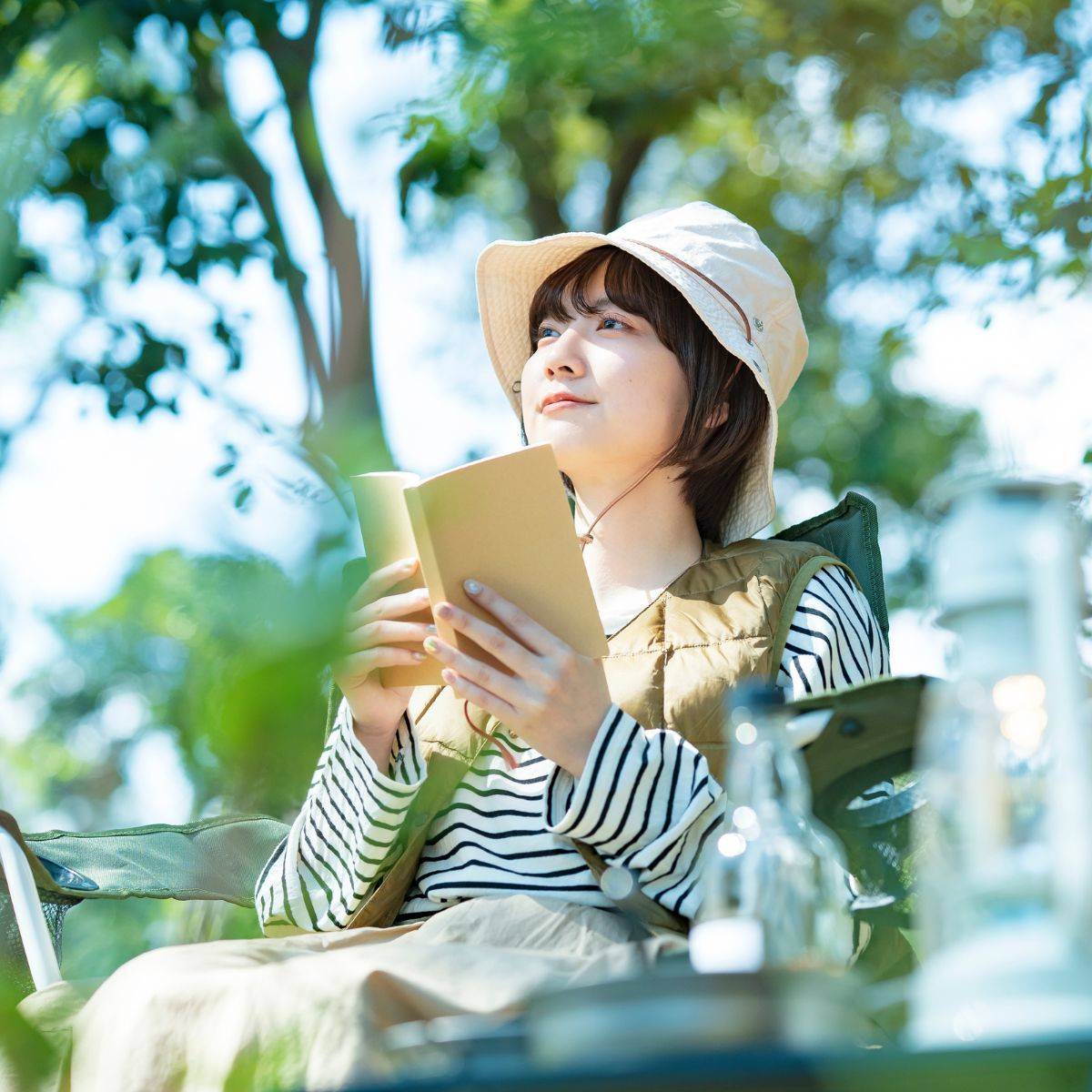 キャンプをしながら本を読む女性