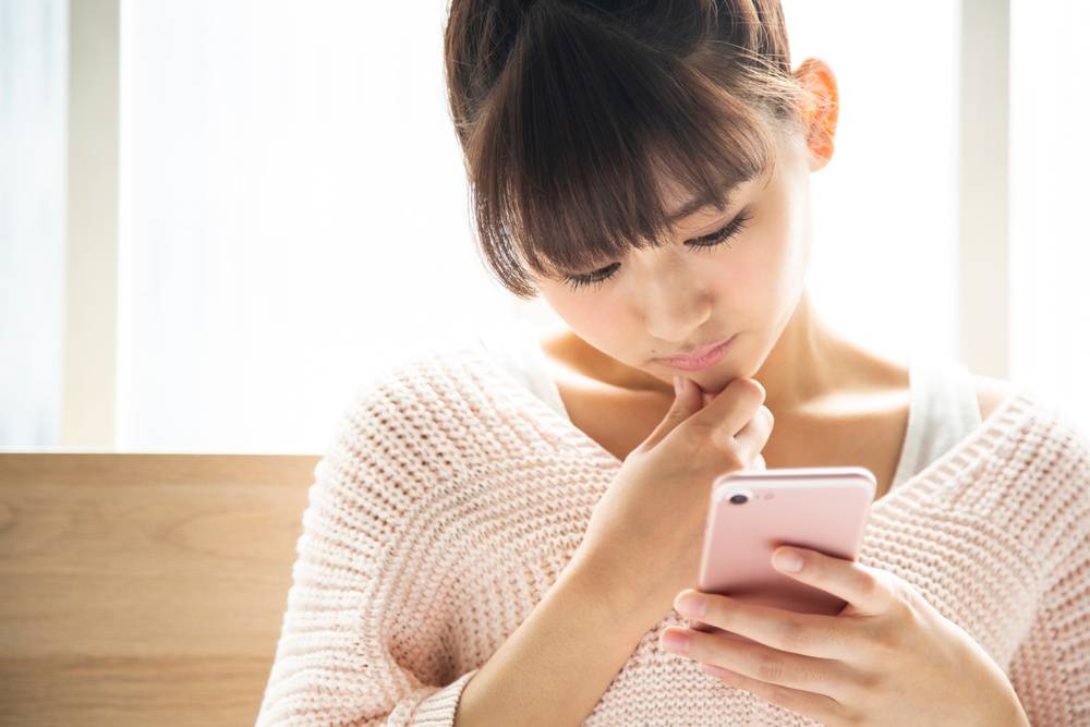 携帯電話を見る女性