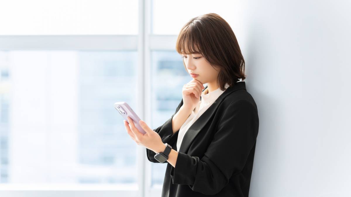スマホを見て考えている女性