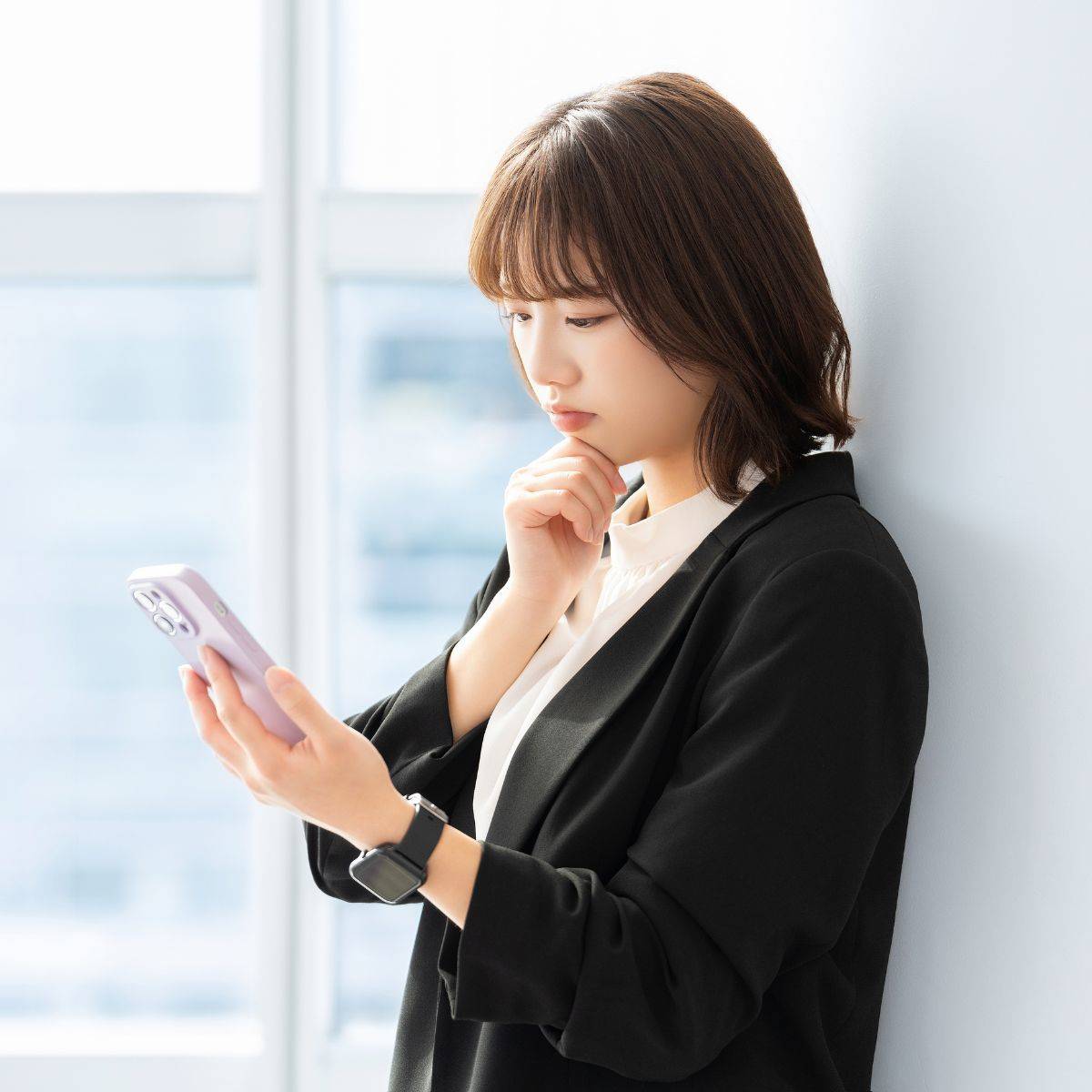 スマホを見て考えている女性