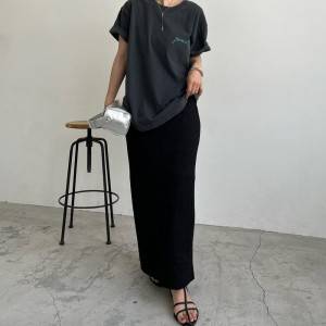  グレーのTシャツに黒スカートを合わせた女性 