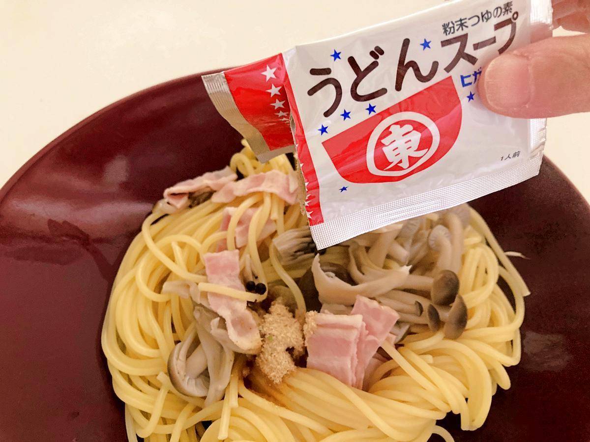 茹で上がったスパゲティにヒガシマルうどんスープをかける様子