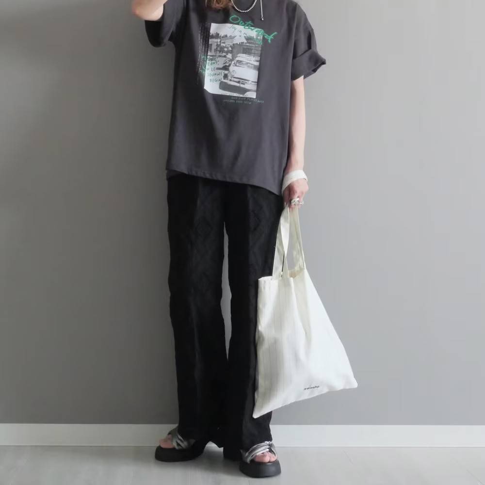グレーTシャツに黒パンツを合わせた女性