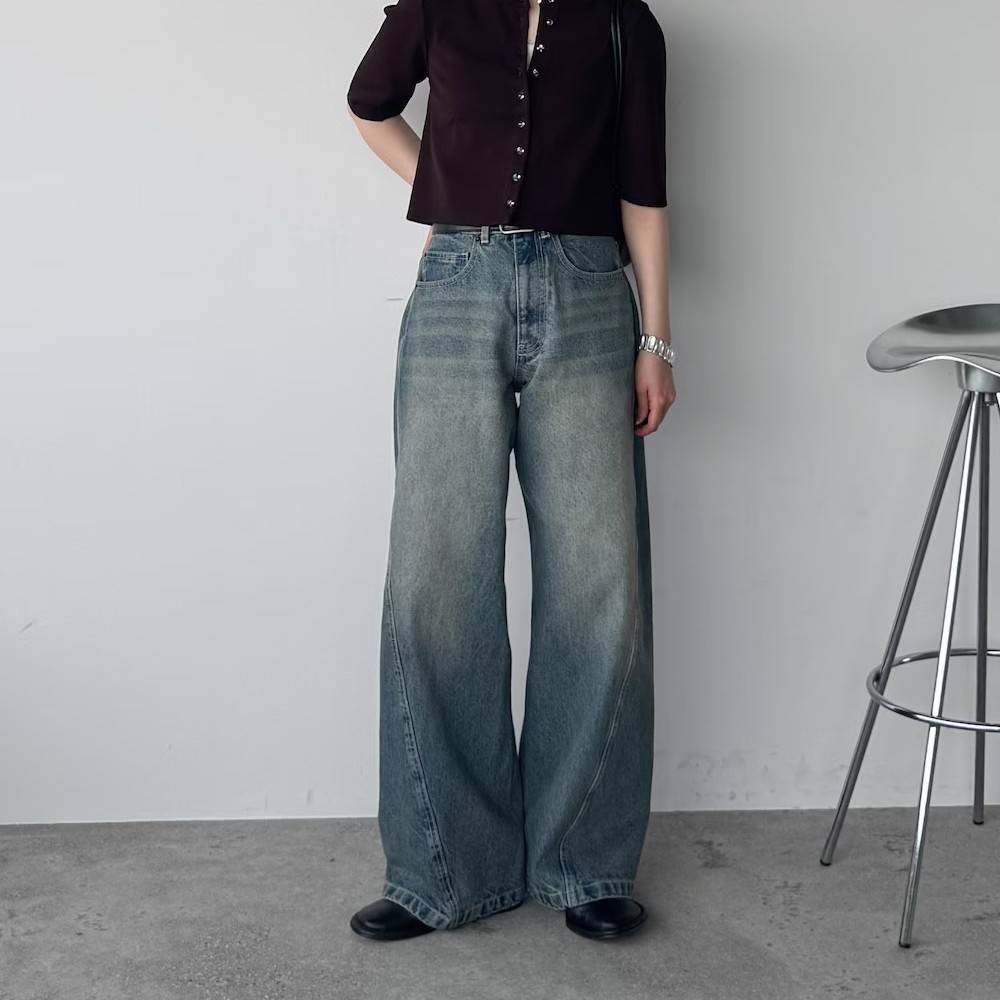 黒カーディガンにデニムパンツを合わせた女性