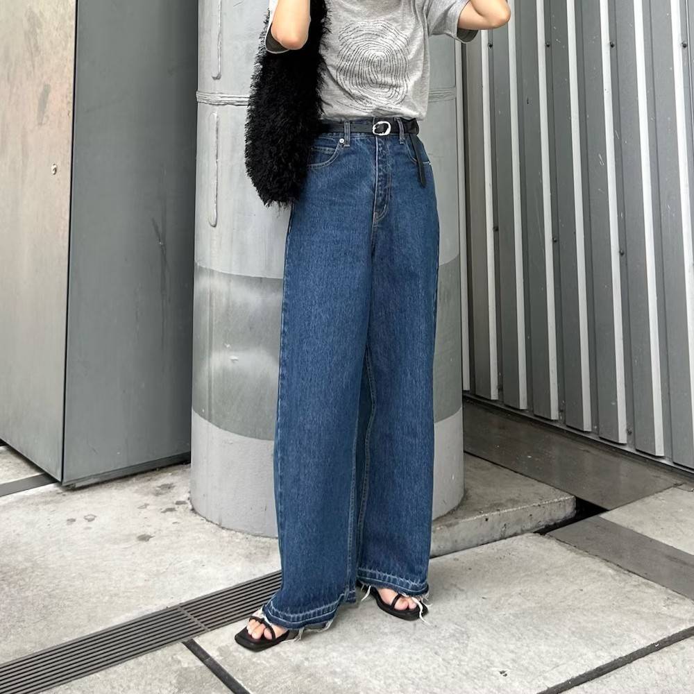 グレーのTシャツにデニムパンツを合わせた女性