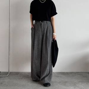  黒Tシャツにグレーパンツを合わせた女性 
