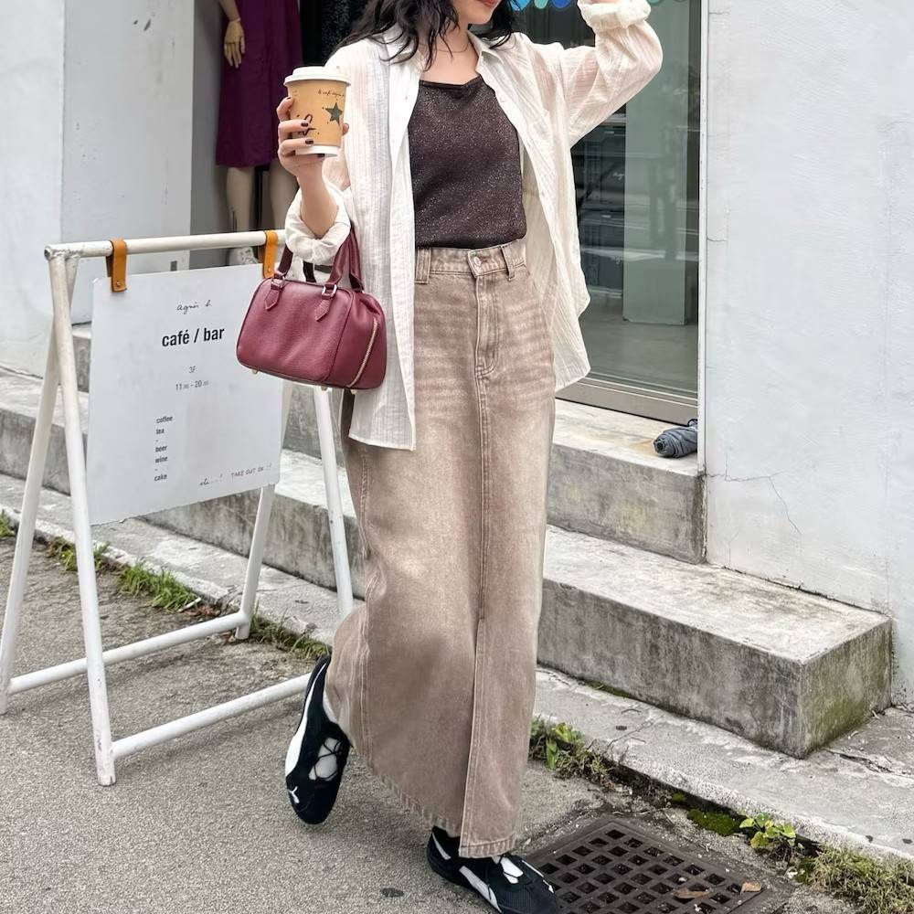 白シャツにベージュのスカートを合わせた女性