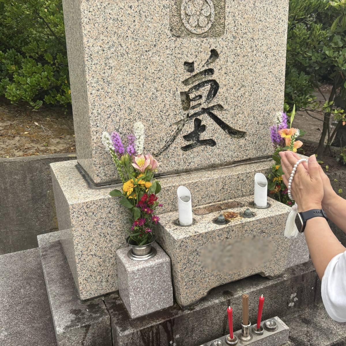 お墓に手を合わせている写真