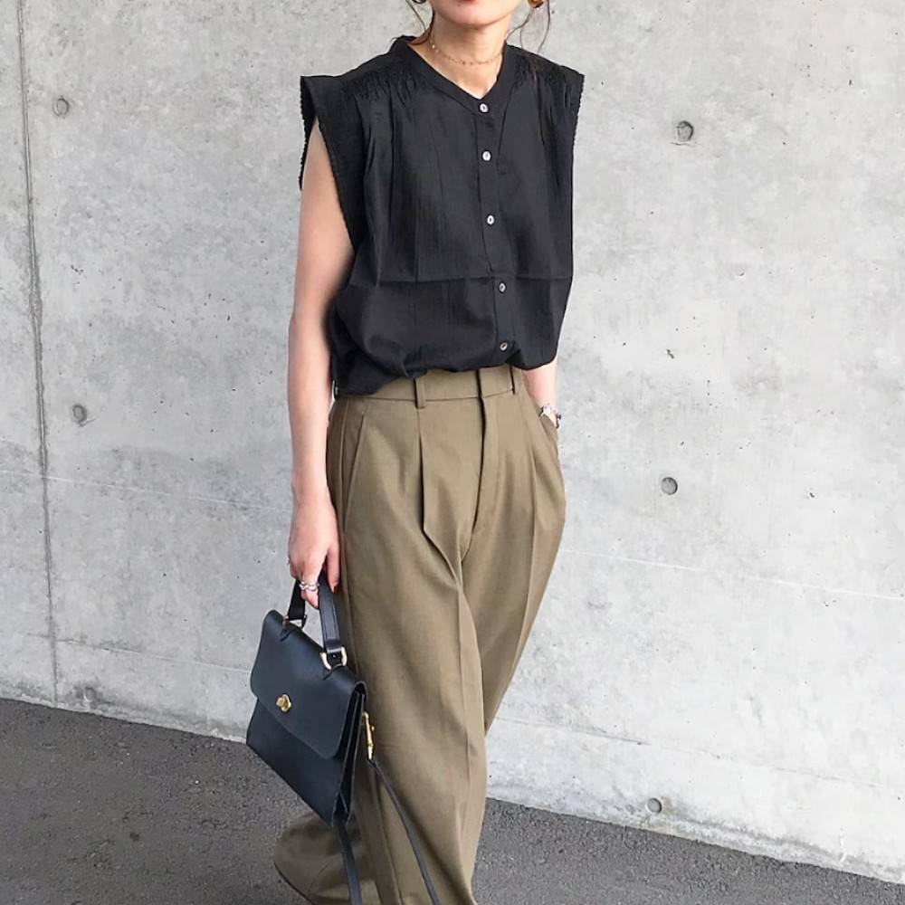 黒シャツにベージュのパンツを合わせた女性