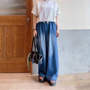  白Tシャツにデニムパンツを合わせた女性 