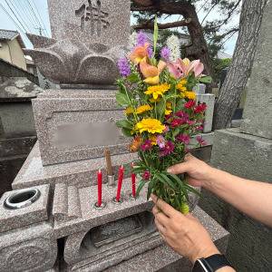  お墓に花を供えている写真 
