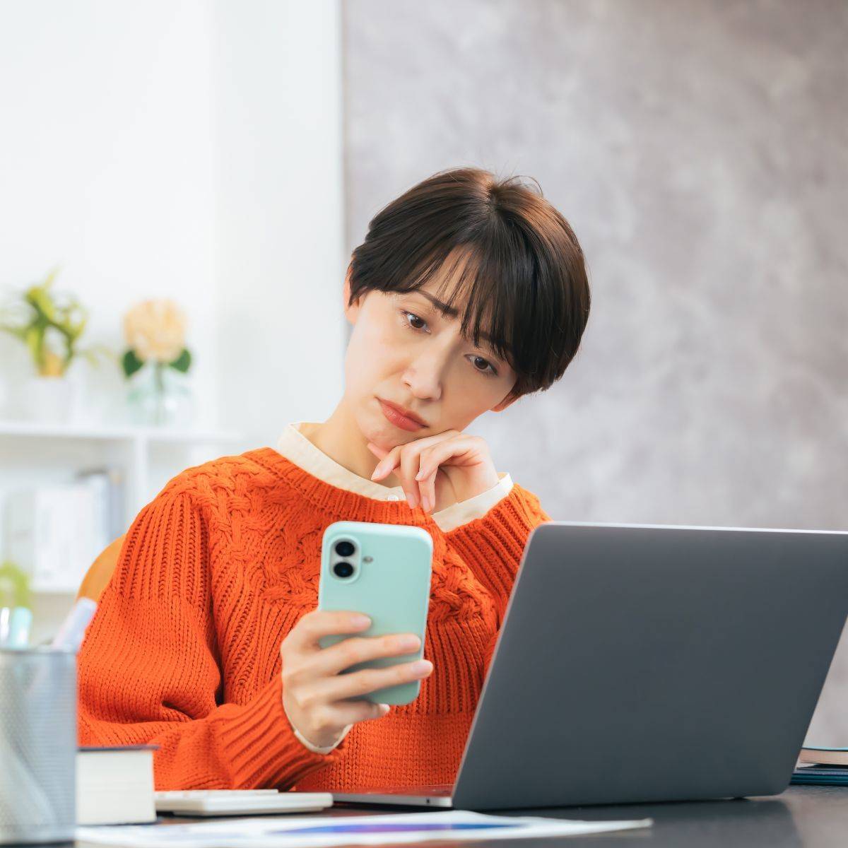 スマートフォンを見て悩んでいる女性