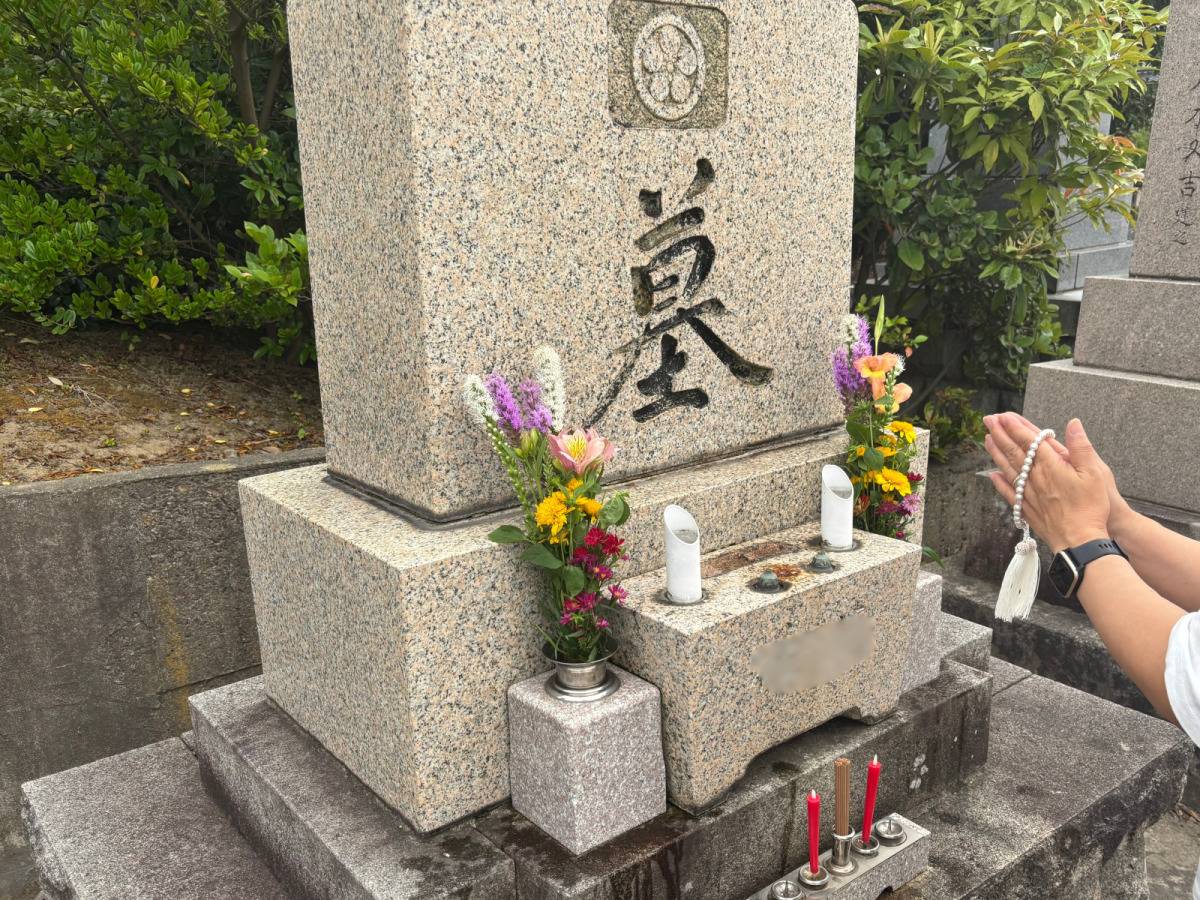 お墓に手を合わせている写真