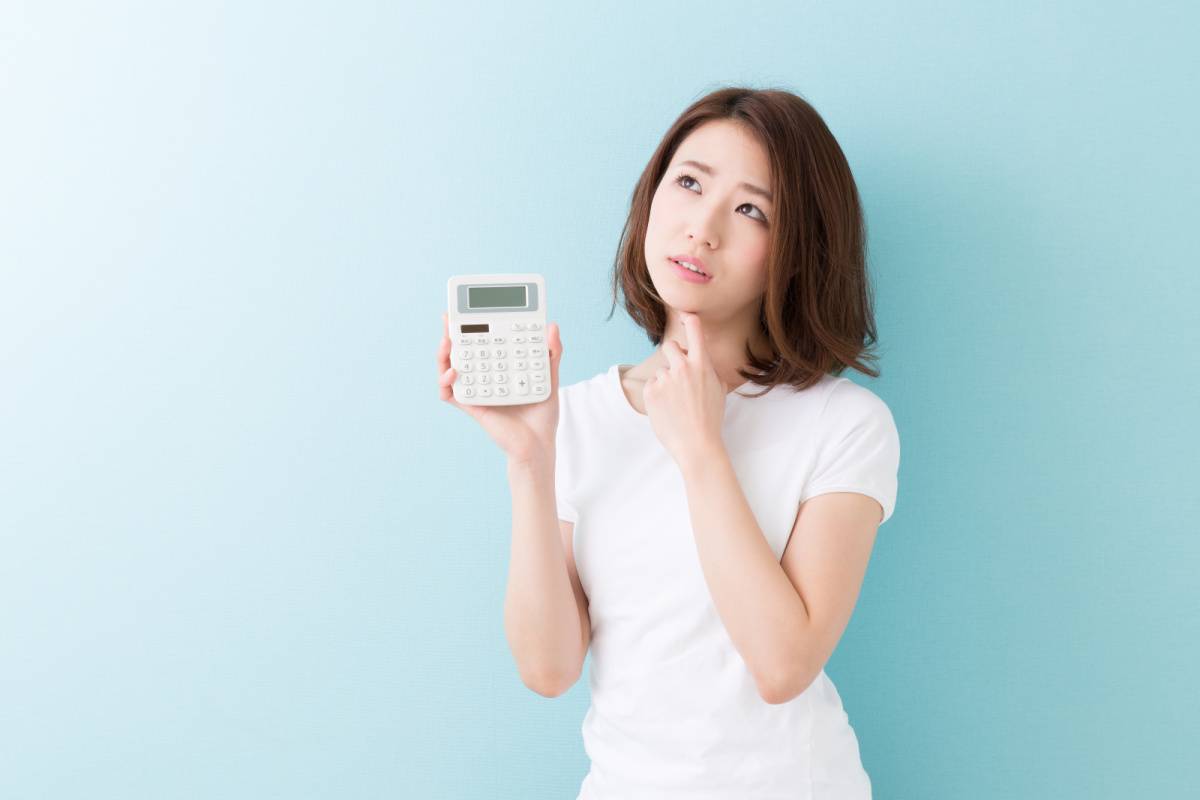 電卓を手に悩んでいる女性