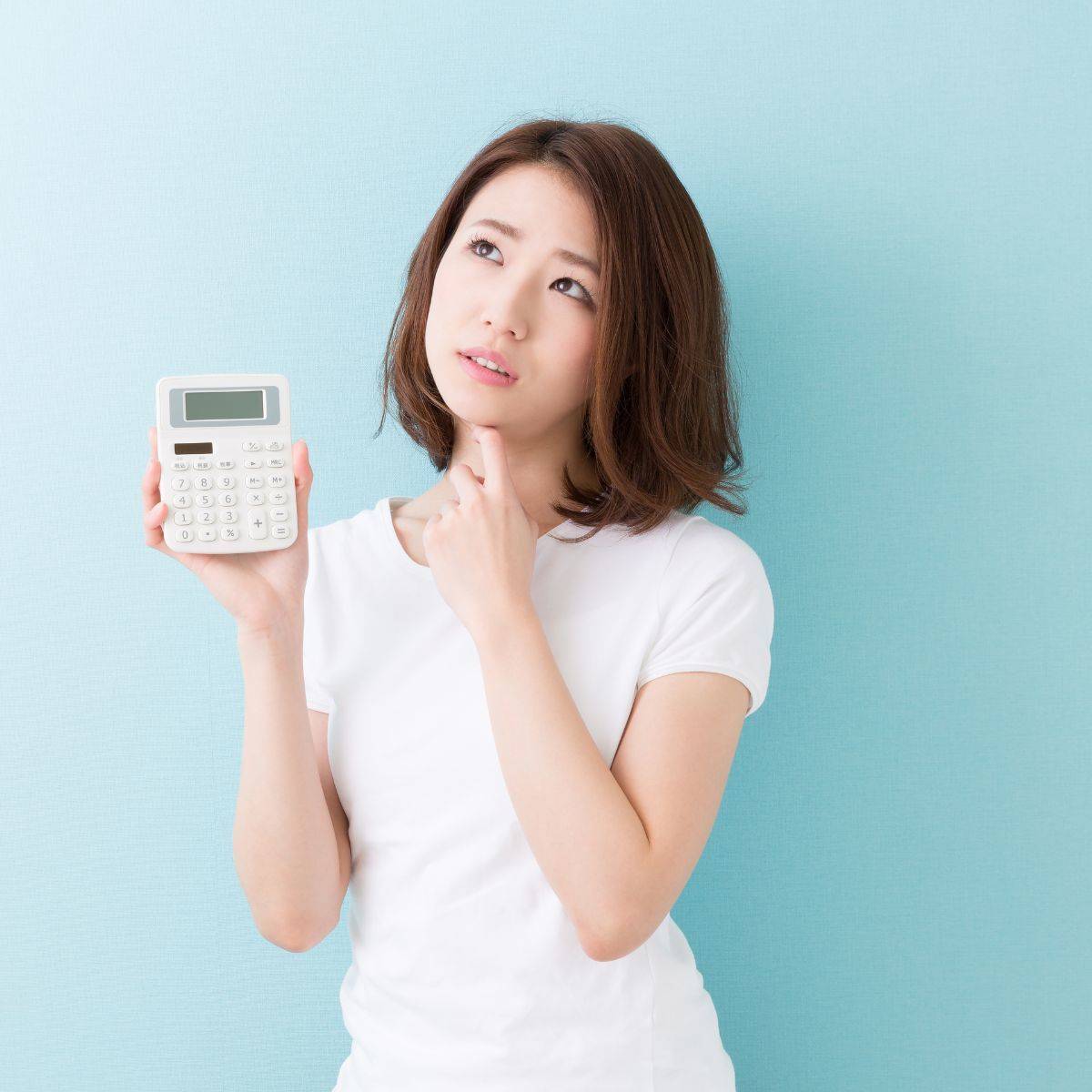 電卓を手に悩んでいる女性