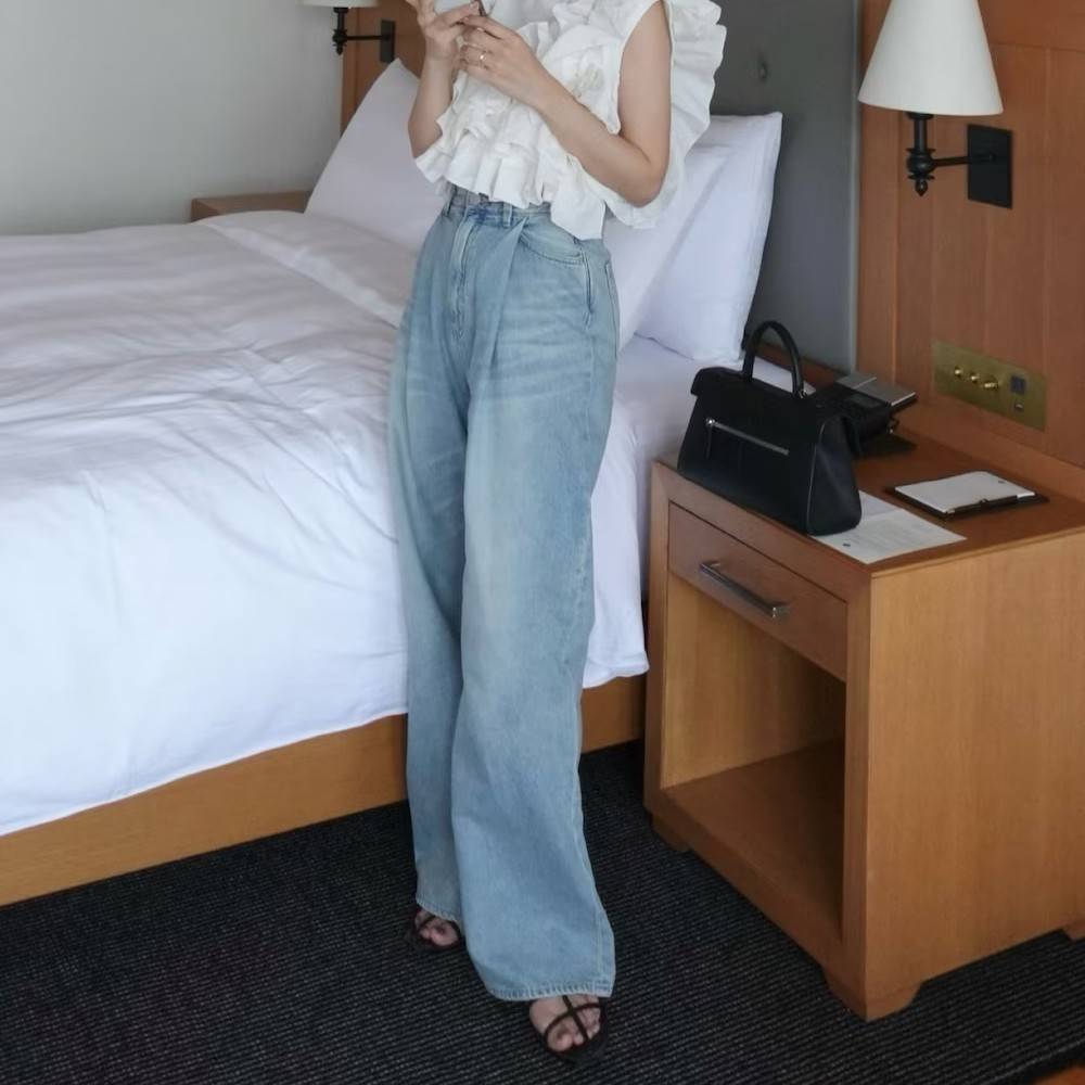 白トップスにデニムパンツを合わせた女性