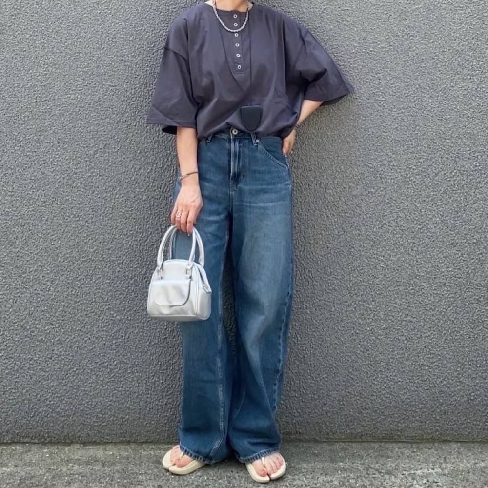 グレーのTシャツにデニムパンツを合わせた女性