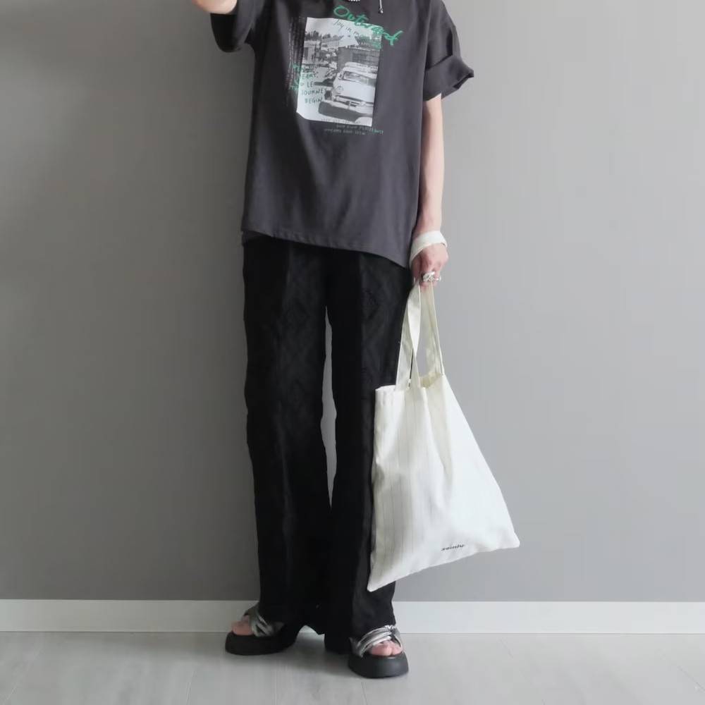 グレーのTシャツに黒パンツを合わせた女性