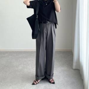  黒トップスにグレーパンツを合わせた女性 