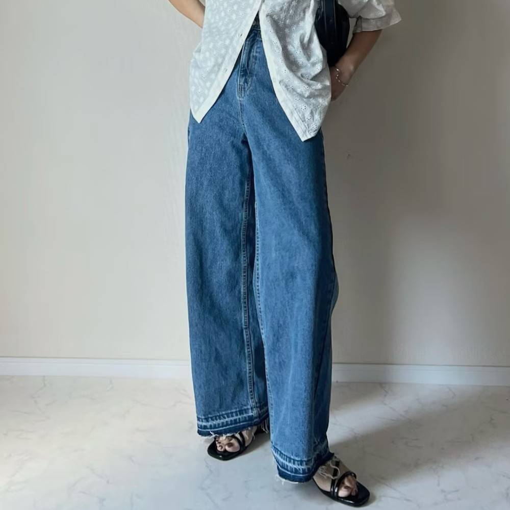白ブラウスにデニムパンツを合わせた女性