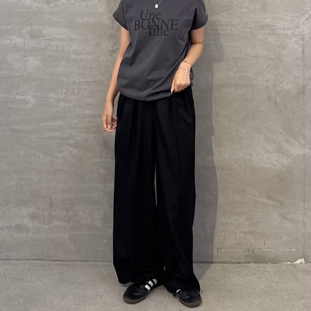 グレーのTシャツに黒パンツを合わせた女性