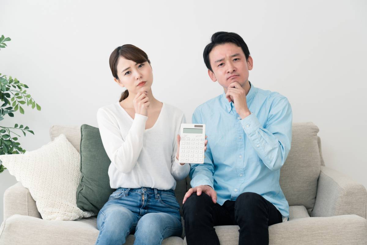 電卓を手に悩んでいる夫婦