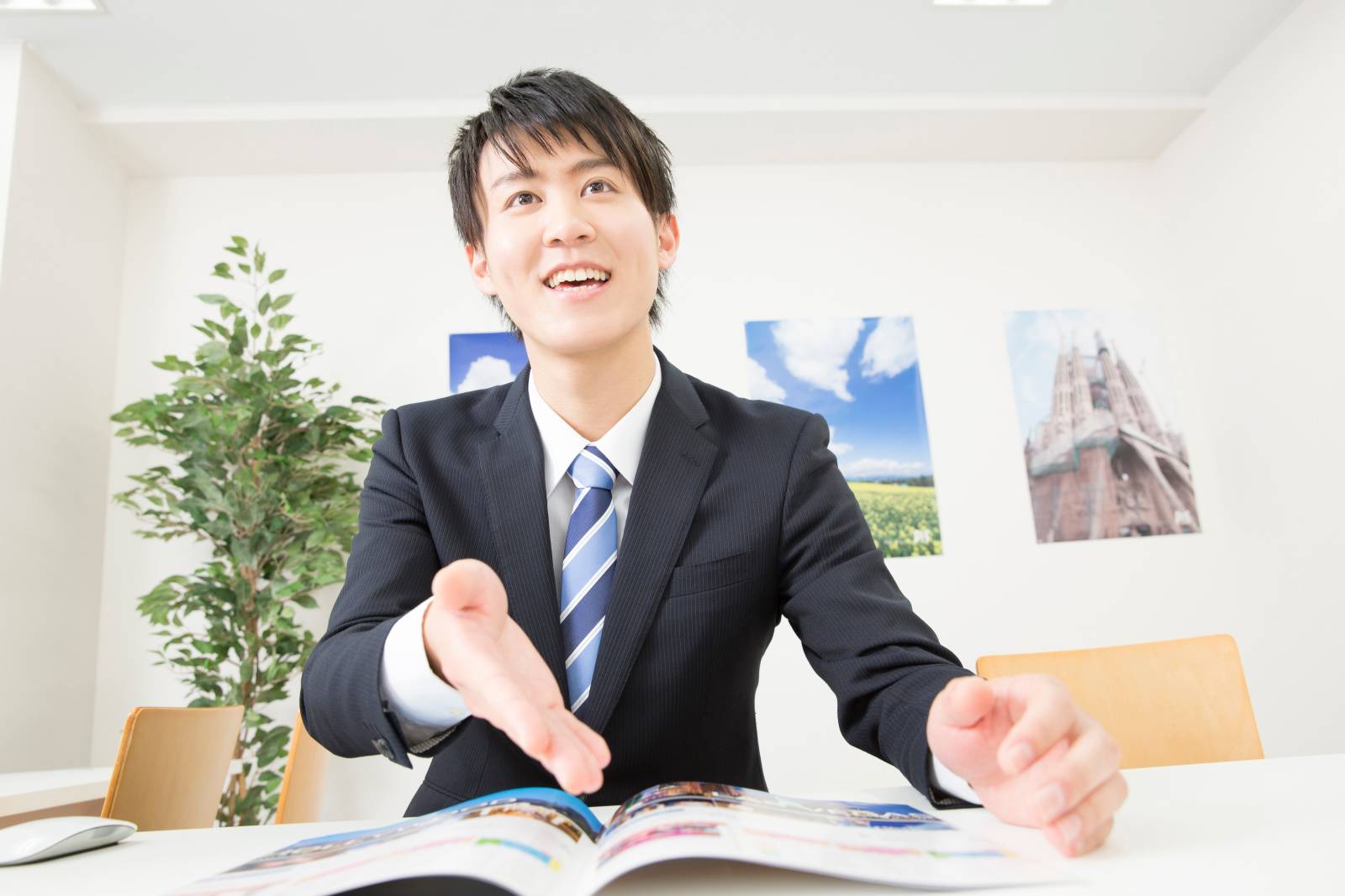 接客をする旅行代理店の男性スタッフ 