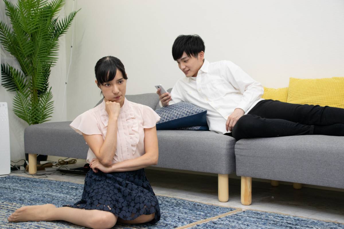 スマホを見ている夫と怒っている妻