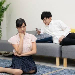  スマホを見ている夫と怒っている妻 
